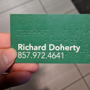 Back of the Starbucks business card, showing a green background with large white sans-serif font with manager name and phone number