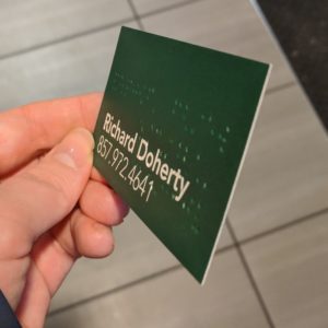 Image of the business card held at a angle to demonstrate the thickness
